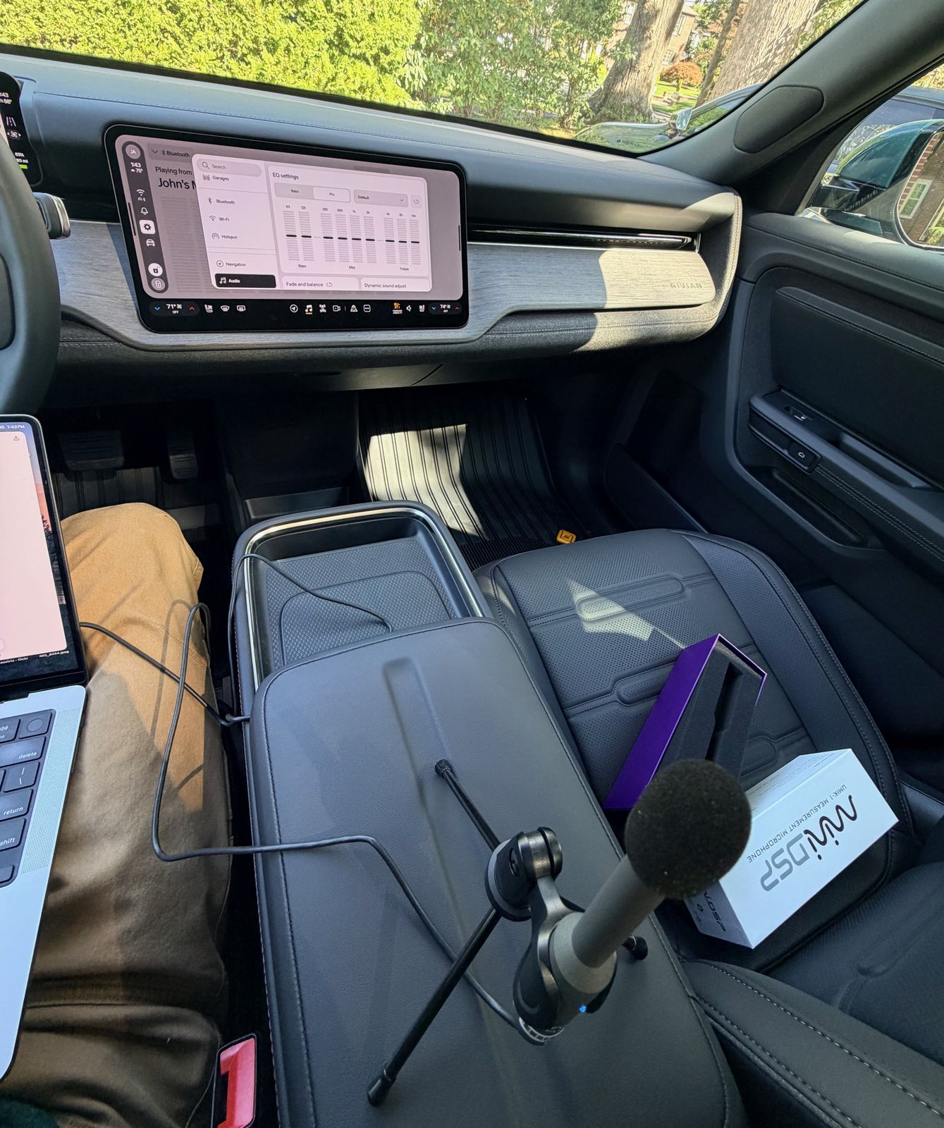 UMIK-1 measurement mic on a tripod on the R2's center console, with the miniDSP box on the passenger seat and the R2's EQ screen in the background showing all sliders flat